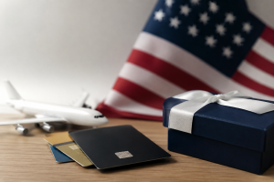Realistic and minimalist scene representing reward programs in the United States. A modern credit card rests on a clean wooden desk beside a smartphone displaying a generic loyalty app interface with no visible text. In the background, subtle travel-inspired elements such as a boarding pass silhouette, a small suitcase, and a coffee cup suggest everyday spending and lifestyle benefits. Soft natural lighting, balanced contrast, and a professional composition create a polished visual associated with Investments, financial planning, and maximizing consumer rewards through strategic purchasing habits.